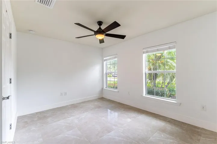 Unfurnished room with a ceiling fan, a smoke detector, and light marble finish floors