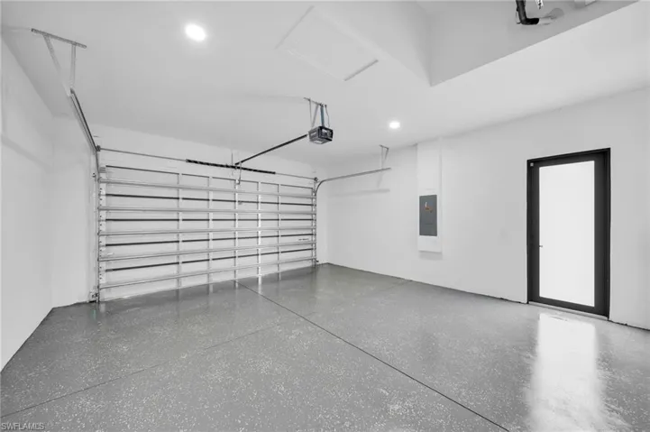 Garage featuring a garage door opener and electric panel