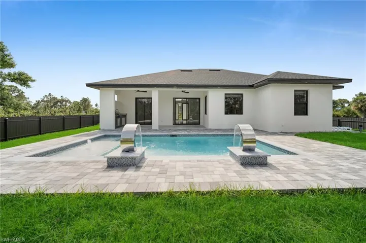 Rear view of house featuring a ceiling fan, a fenced backyard, a patio, stucco siding, and a fenced in pool