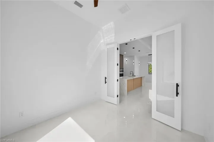 Empty room with visible vents, marble finish floor, and a sink