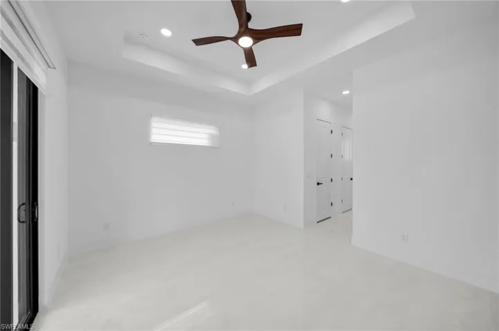 Unfurnished room with a raised ceiling, ceiling fan, baseboards, and recessed lighting