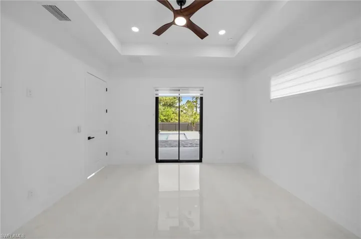 Spare room featuring recessed lighting, visible vents, a ceiling fan, and a raised ceiling