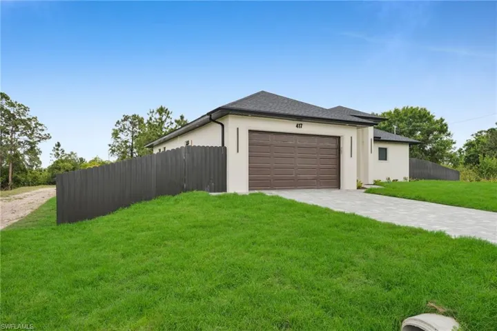 Garage featuring driveway and fence