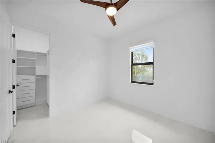 Unfurnished bedroom featuring a closet, ceiling fan, and a spacious closet