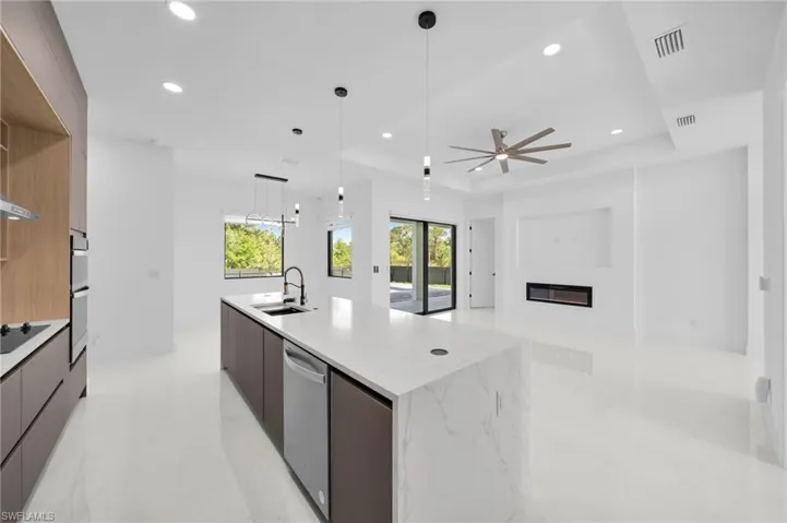 Kitchen featuring visible vents, a raised ceiling, modern cabinets, a sink, and appliances with stainless steel finishes
