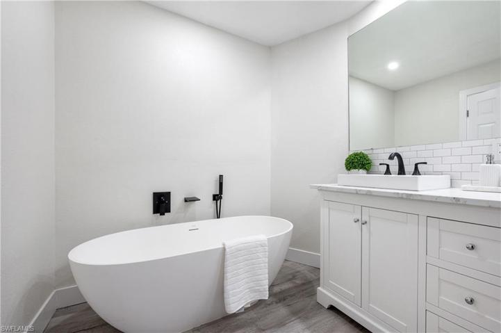 Primary bedroom bathtub and dual sinks.