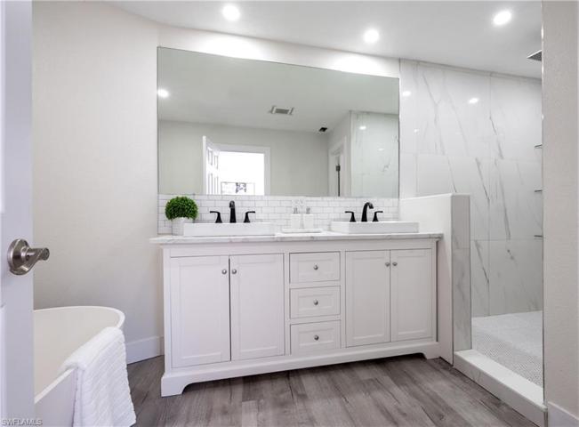 Primary bathroom with dual sinks, shower and bathtub.
