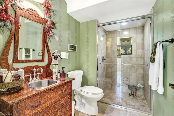 Bathroom with toilet, a stall shower, and vanity