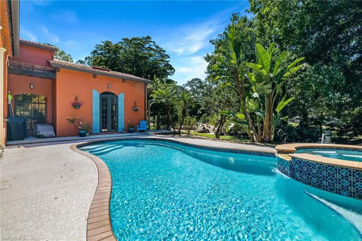 View of swimming pool featuring a patio, french doors, and a pool with connected hot tub