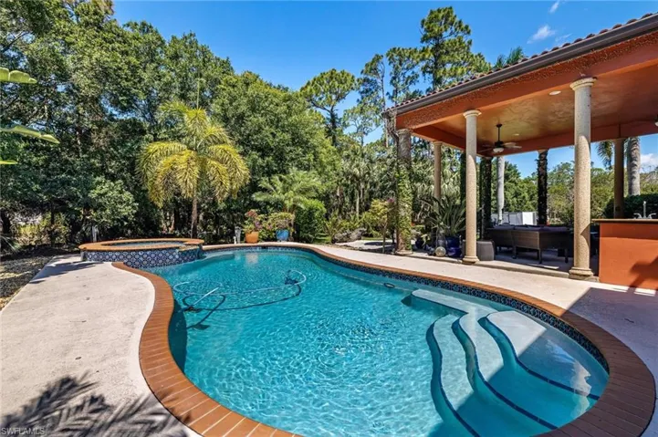 View of swimming pool featuring a ceiling fan, a pool with connected hot tub, and a patio