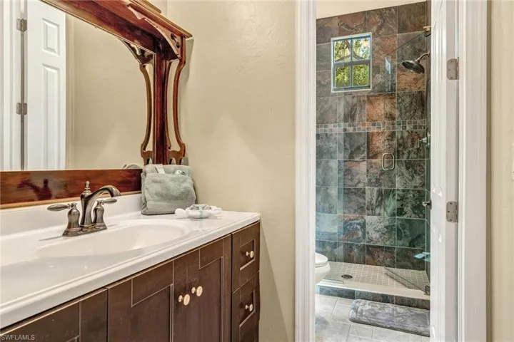 Full bathroom with a shower stall, toilet, and vanity