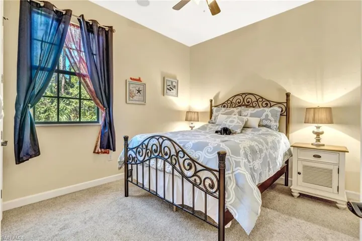 Bedroom with a ceiling fan, carpet floors, and baseboards