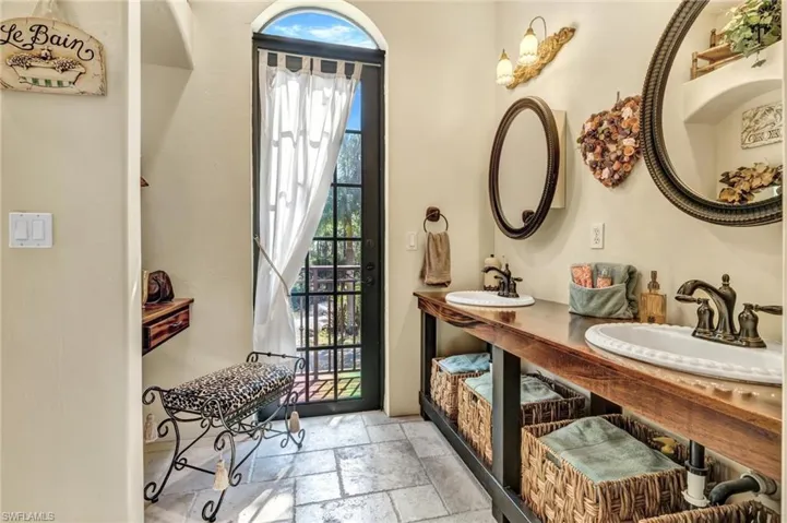Bathroom featuring a sink, plenty of natural light, and stone tile floors