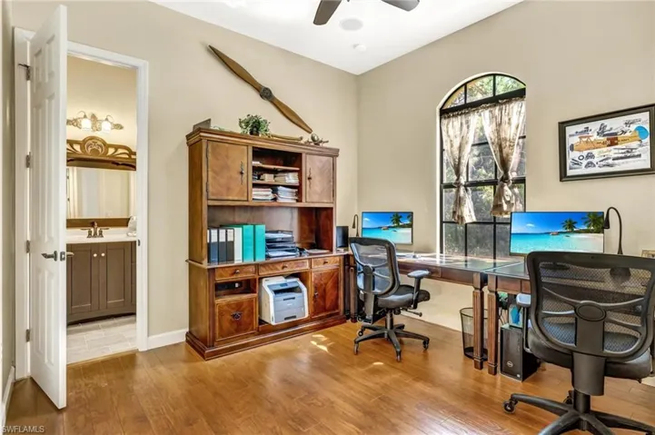 Office with a sink, baseboards, wood finished floors, and a ceiling fan