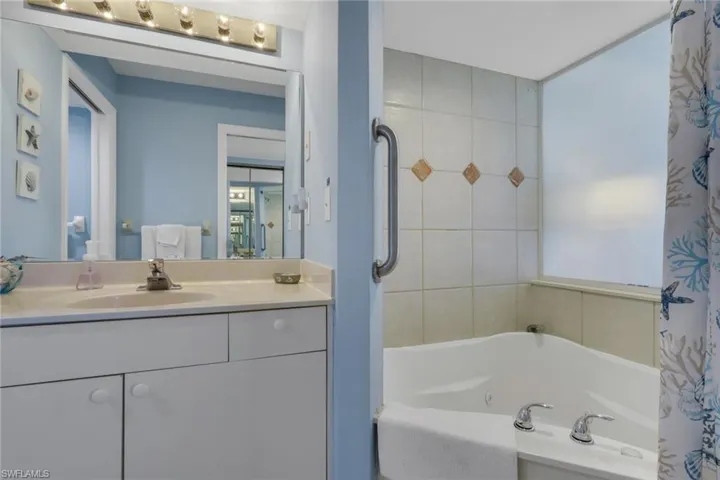 Full bathroom featuring vanity and a combined bath / shower with jetted tub