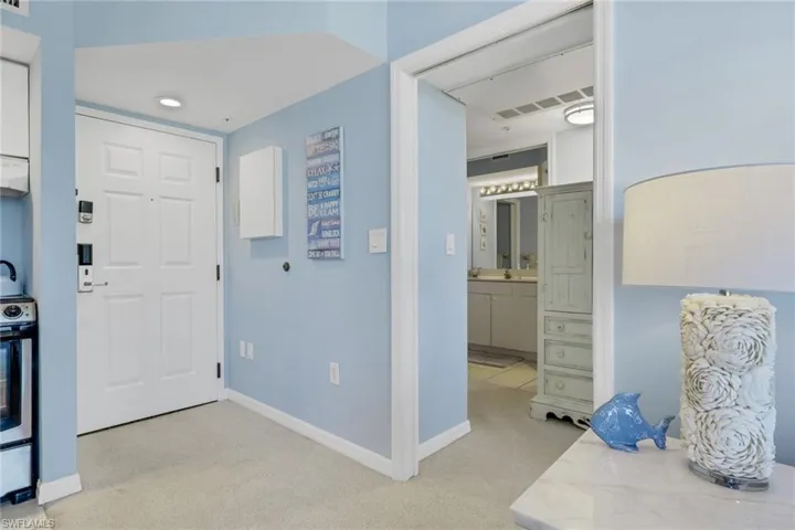 Entrance foyer featuring light carpet and baseboards