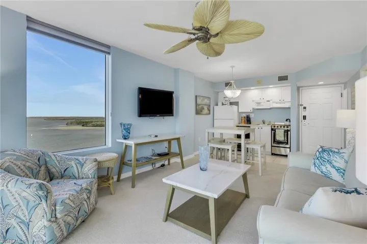 Living room featuring light colored carpet and ceiling fan