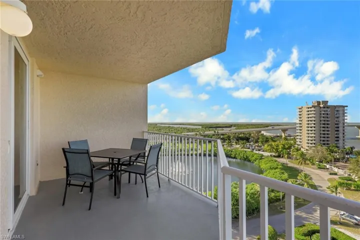Balcony featuring outdoor dining area and a water view