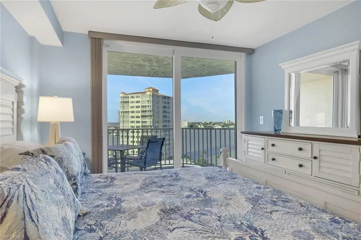 Bedroom with ceiling fan, multiple windows, access to exterior, and a water view