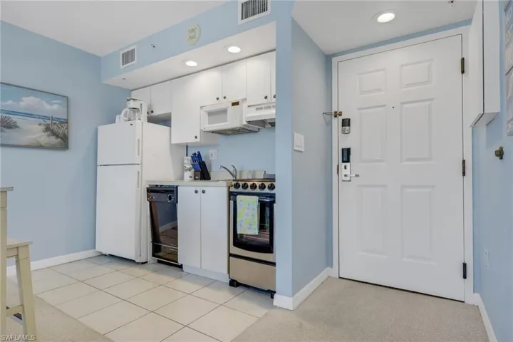 Kitchen with white cabinetry, stainless steel range with electric stovetop, light carpet, light countertops, and recessed lighting