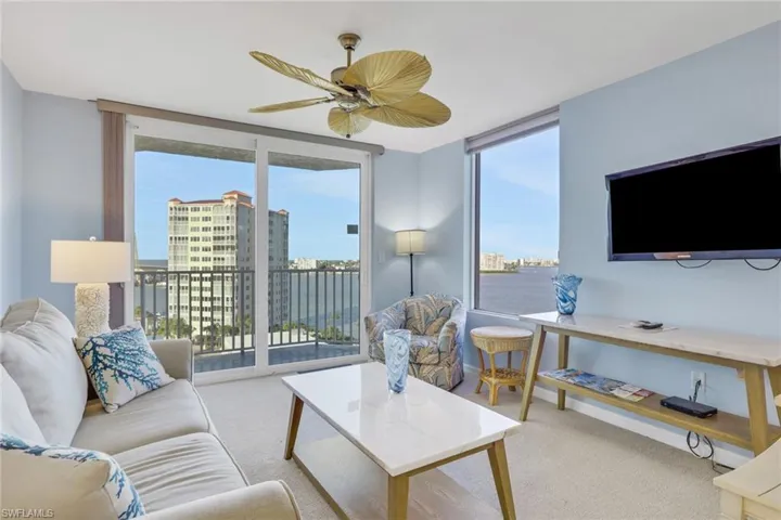 Living room featuring carpet floors, plenty of natural light, a ceiling fan, and floor to ceiling windows