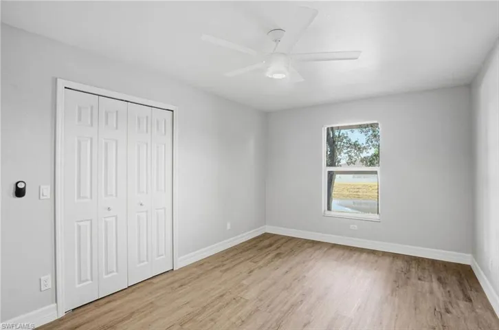 Unfurnished bedroom featuring light wood finished floors, a closet, and ceiling fan