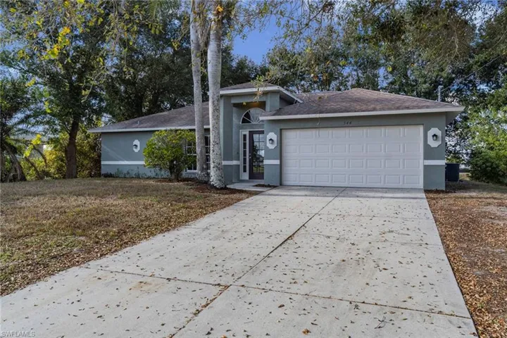 View of front facade with concrete driveway, stucco siding, and a garage
