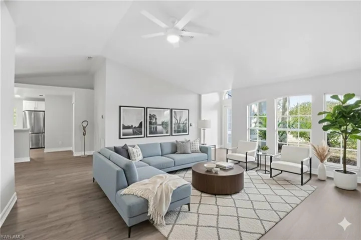 Living area with vaulted ceiling, light wood-type flooring, and ceiling fan