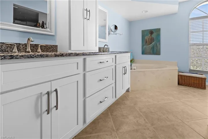 Bathroom with tile patterned flooring, vanity, and a bath