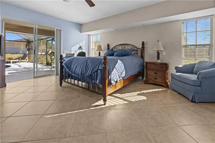 Tiled bedroom featuring access to outside and ceiling fan