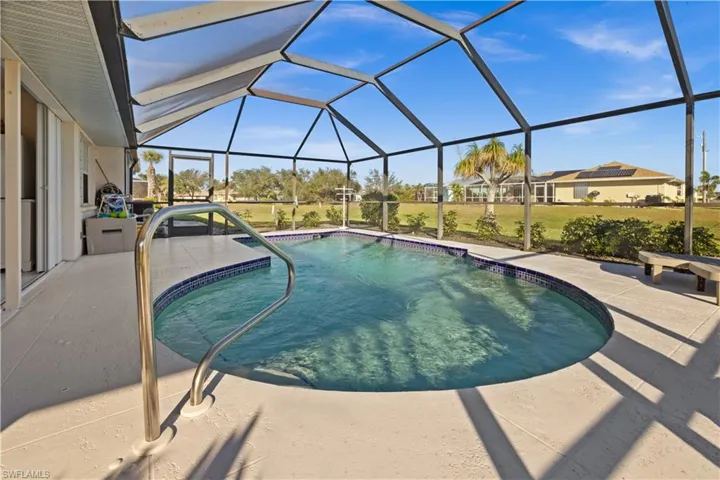 View of swimming pool featuring a yard, glass enclosure, and a patio area