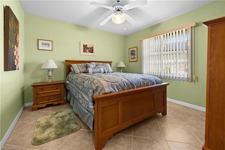 Bedroom with ceiling fan and light tile patterned floors