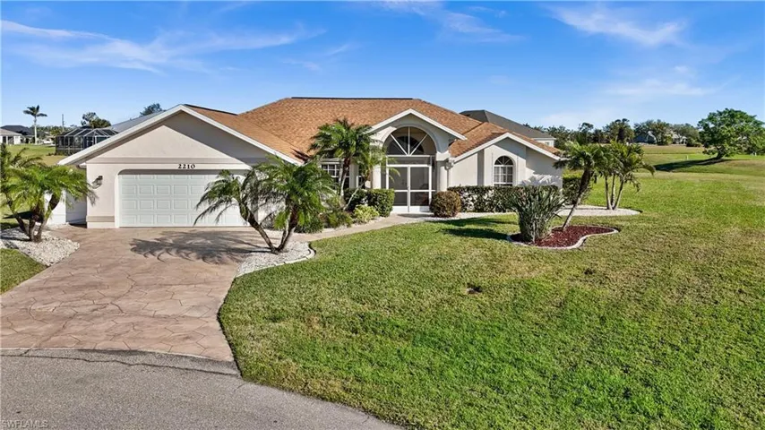 View of front of property featuring a front lawn and a garage