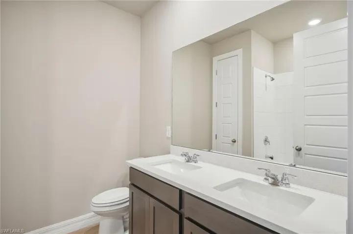 Bathroom with vanity, a shower, and toilet