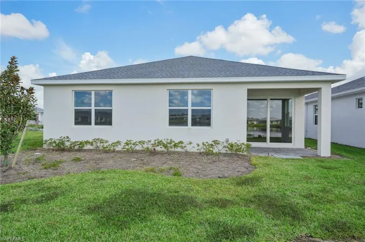 Back of property featuring a lawn and a patio