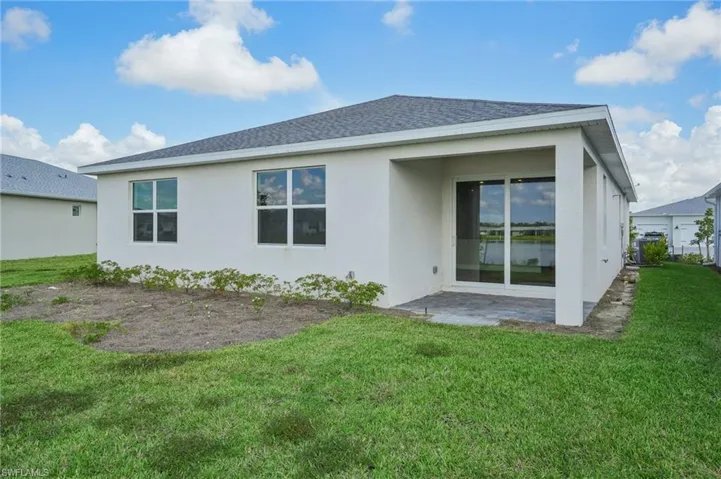 Rear view of house featuring a lawn and a patio