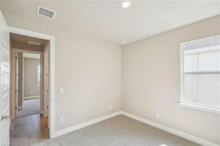 Unfurnished room featuring plenty of natural light and hardwood / wood-style flooring