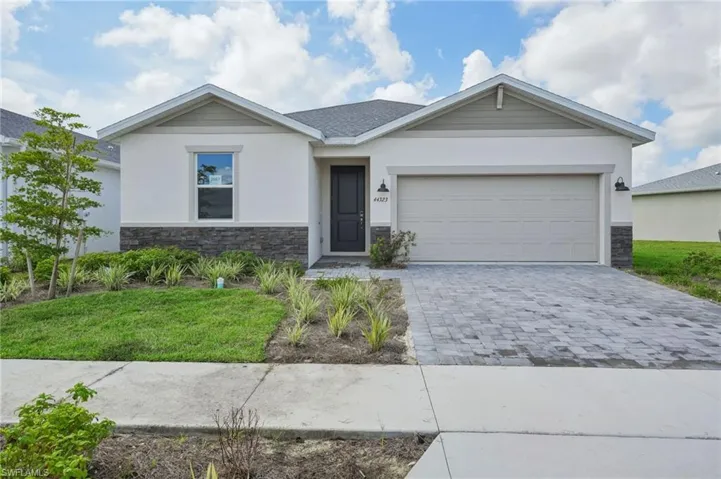 View of front of home with a front lawn and a garage