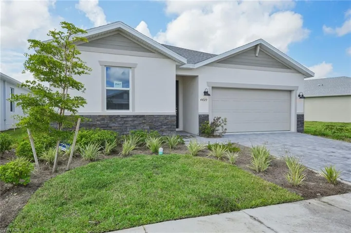 View of front of property with a front yard and a garage