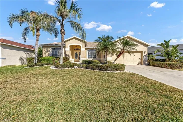 View of front of home with a garage and a front lawn