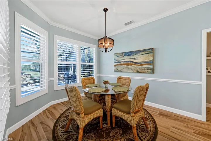 Dining area featuring ornamental molding and wood-type flooring