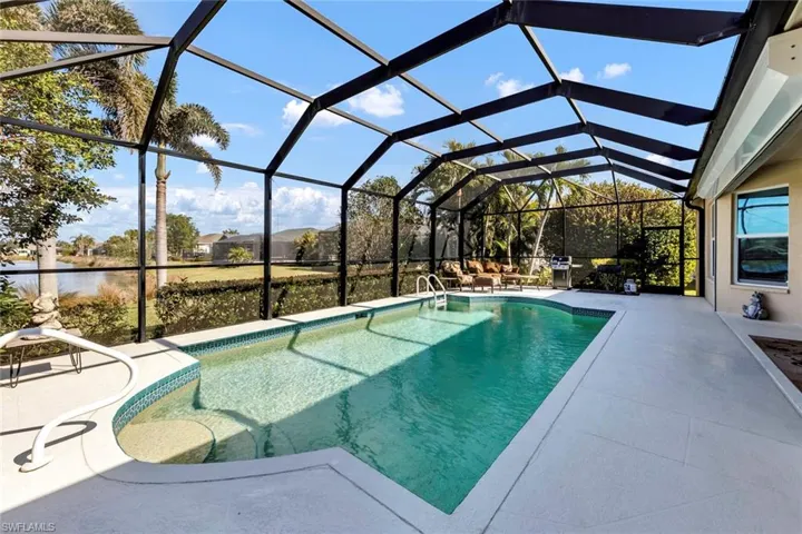 View of pool featuring a grill, a lanai, a patio area, and a water view