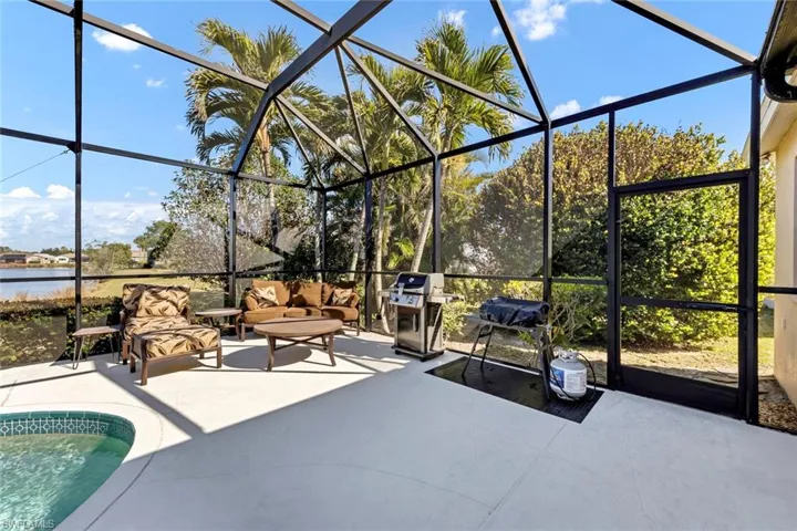 View of patio / terrace with a water view, grilling area, a lanai, and an outdoor hangout area