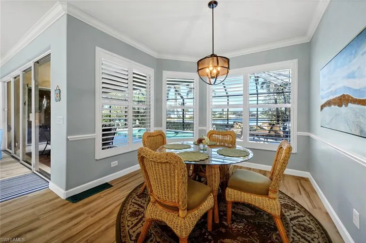 Dining space featuring crown molding, a chandelier, and light wood-type flooring