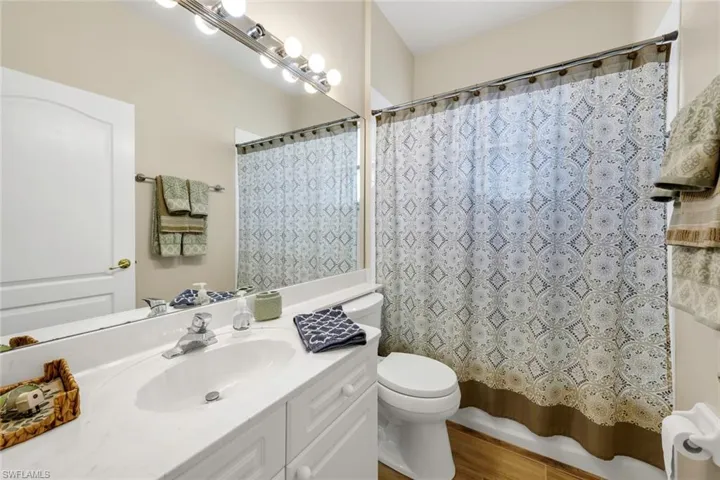 Bathroom featuring vanity, hardwood / wood-style flooring, toilet, and walk in shower
