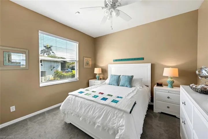 Bedroom featuring ceiling fan and dark colored carpet