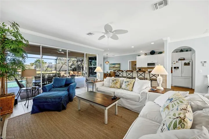 Living room featuring crown molding, light hardwood / wood-style flooring, and ceiling fan
