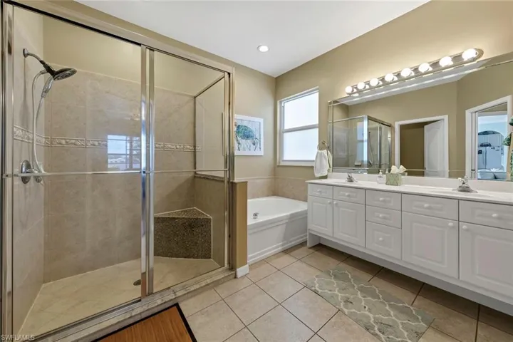 Bathroom with tile patterned flooring, vanity, and separate shower and tub