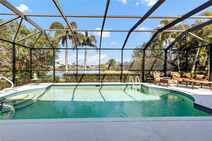 View of pool with a water view, an outdoor living space, a patio area, and glass enclosure