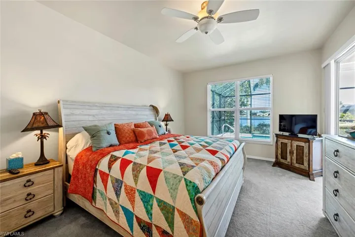 Carpeted bedroom featuring ceiling fan